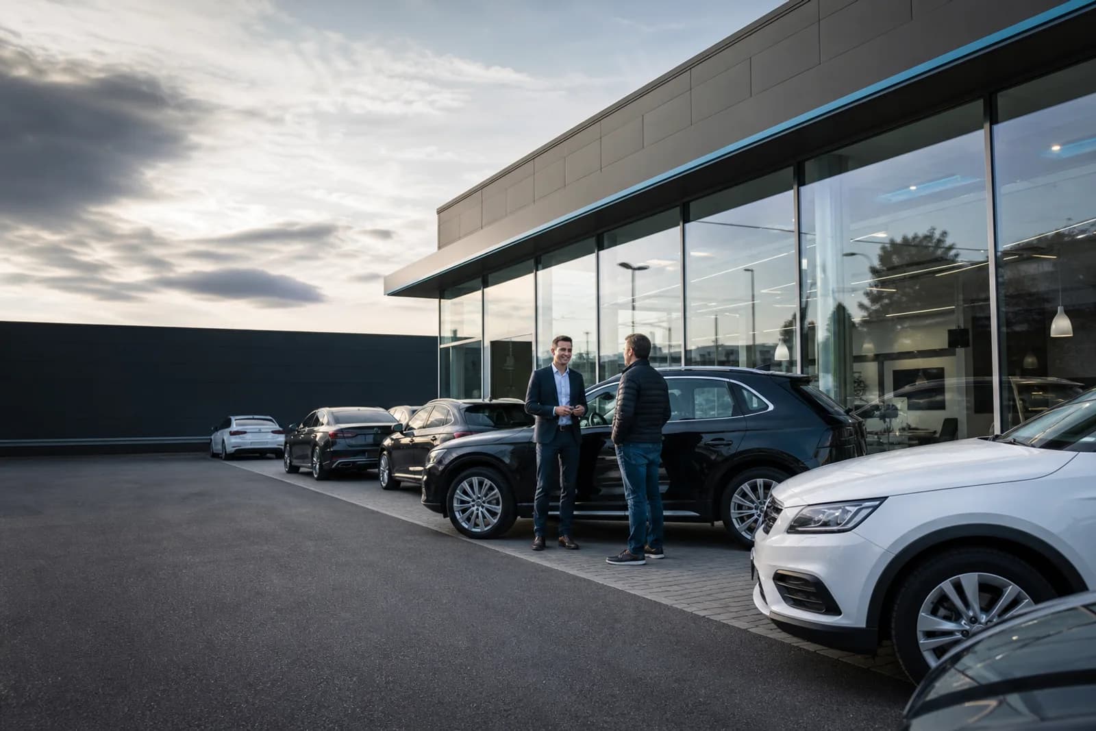 Persönliche Fahrzeugberatung vor einem modernen Autohaus